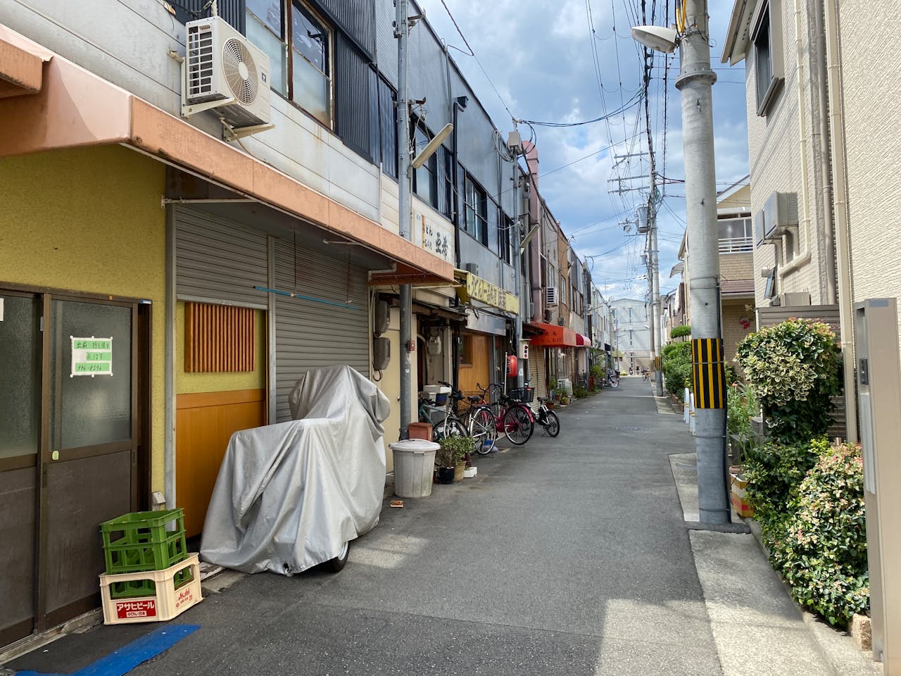 Charming urban alley in Japan with bicycles and buildings, showcasing a peaceful residential street.